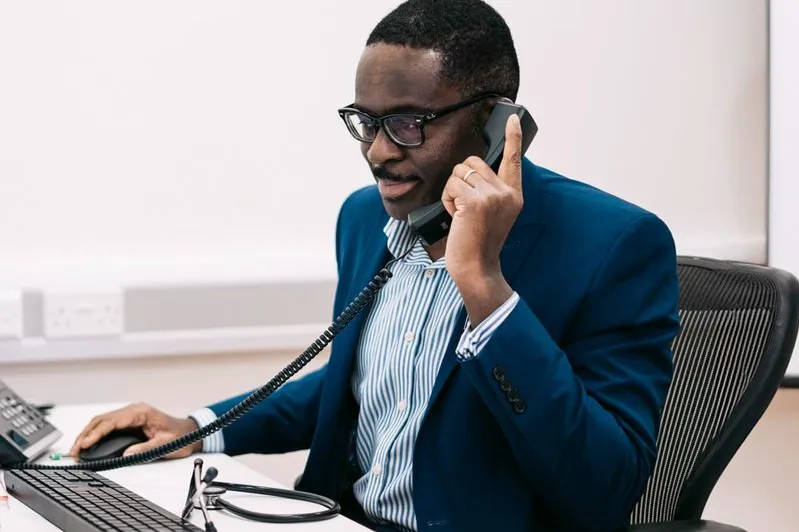 Doctor Ike Nnene on the phone with a client discussing the next steps of a home detox