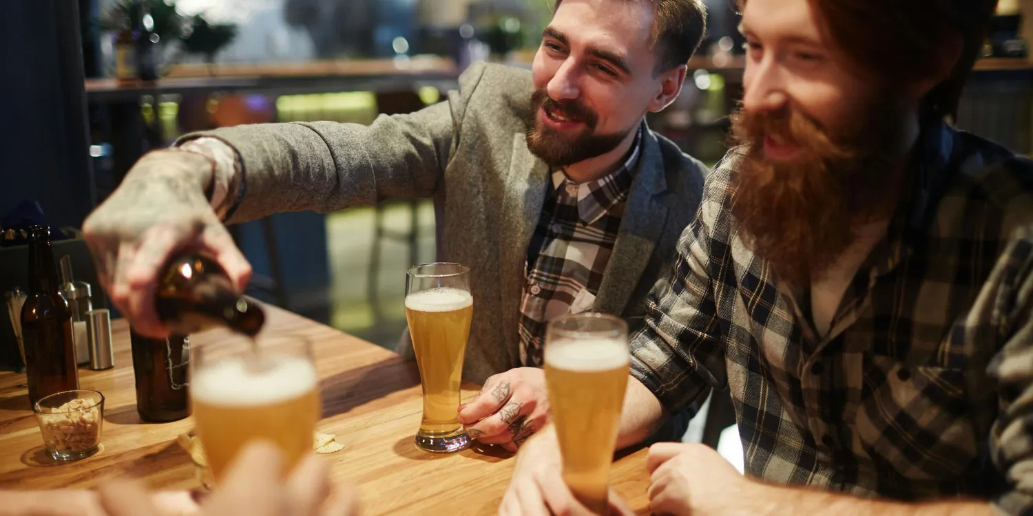 Men at the pub sober shaming one another into drinking