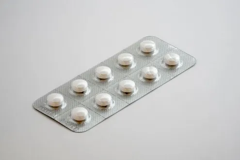 Blister pack containing white round tablets on a plain white background.