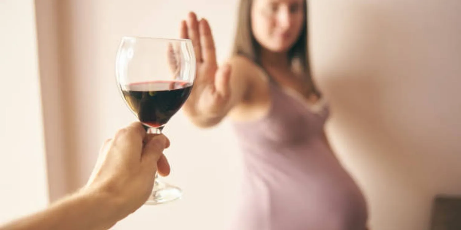 Pregnant woman saying no to red wine, she knows that it can be a cause of FASD.