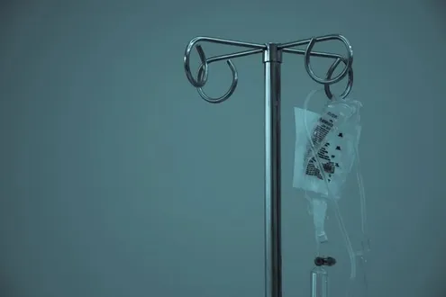 An intravenous drip containing Ketamine hangs from a medical pole. It is being used to treat the person therapeutically