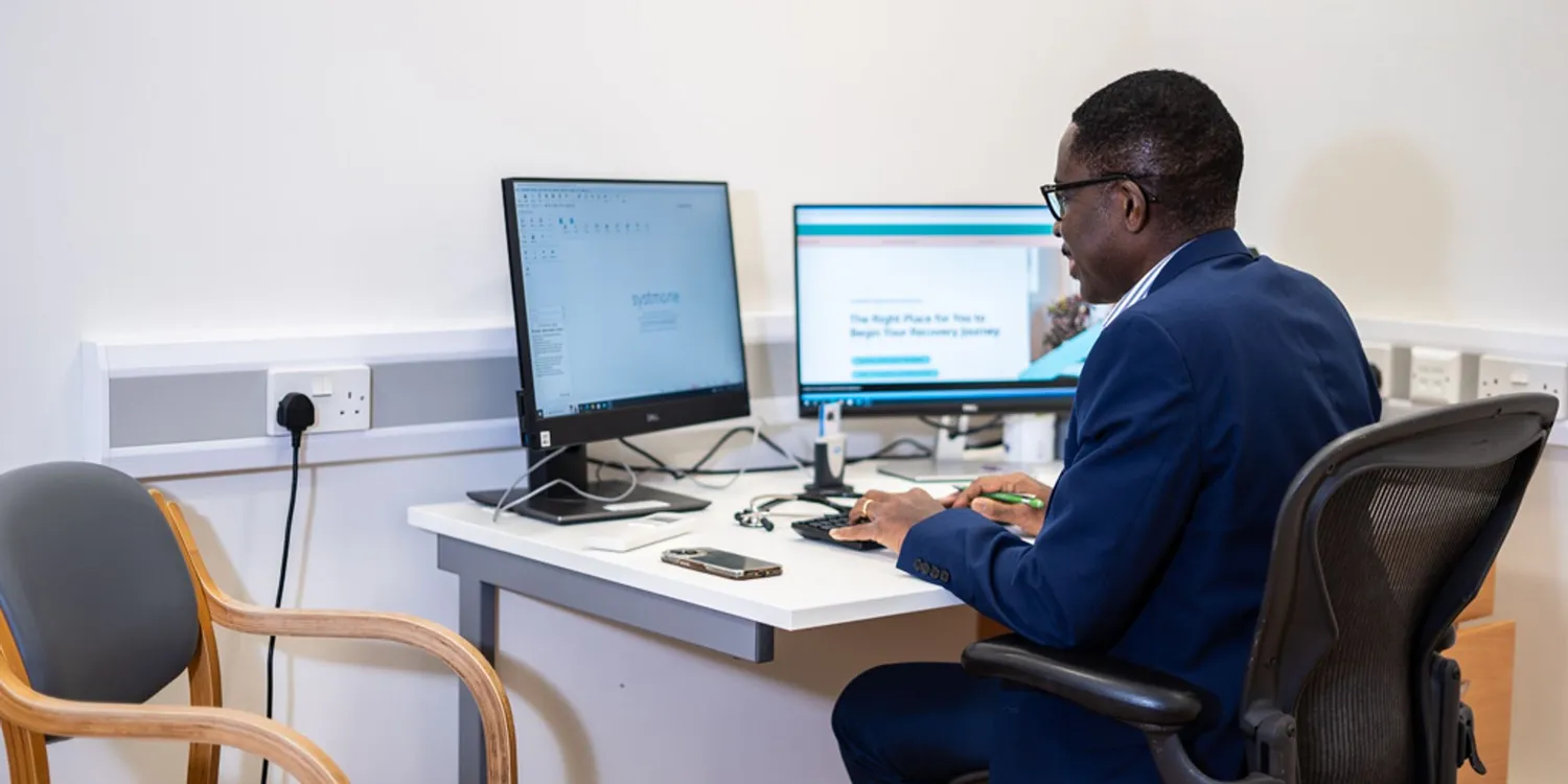 Dr Ike Nnene Private General Practitioner sat at his desk