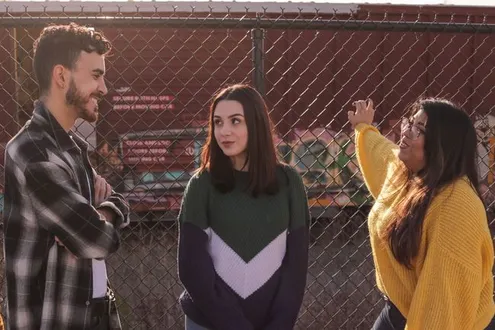 Two young female teenagers speak with a man about alcohol and drug addiction