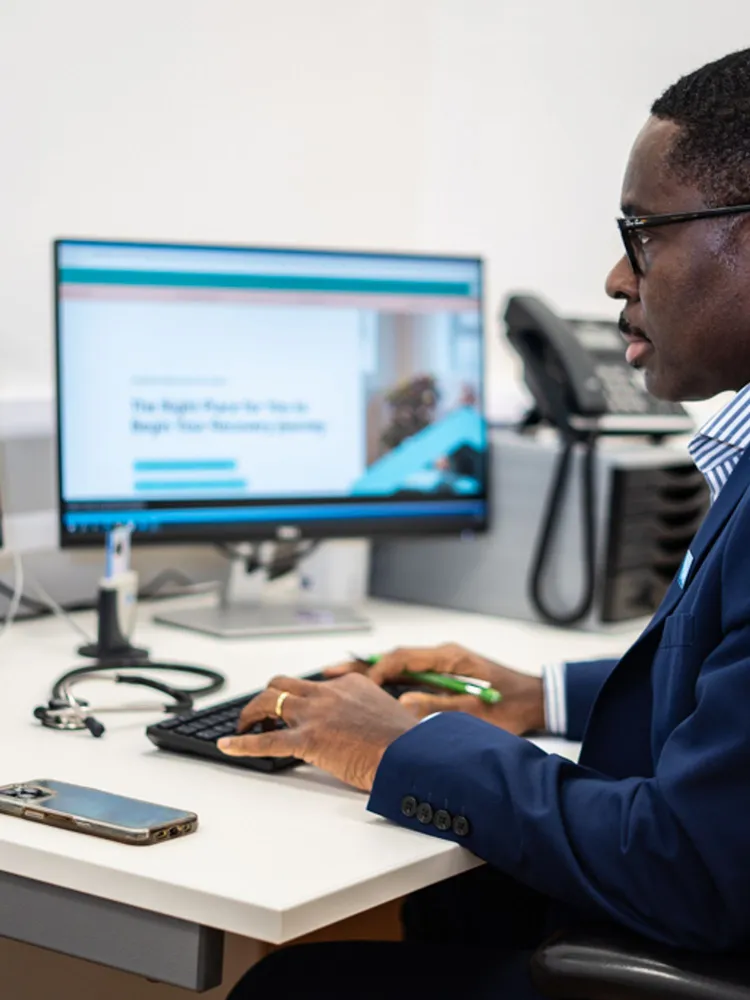 Dr Ike Nnene Private General Practitioner sat at his desk working