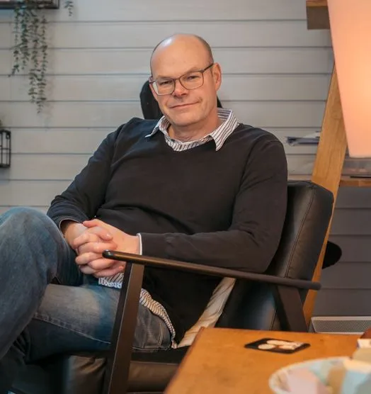 Therapist Mike Broad from Rehabs UK sits in a chair opposite a client engaging in face to face therapy for addiction