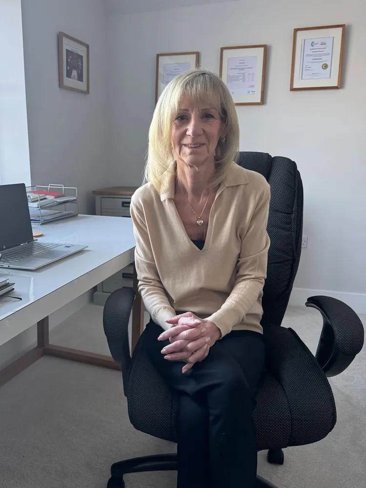 Picture of Carolyn Bell female EMDR Practitioner sat at her desk