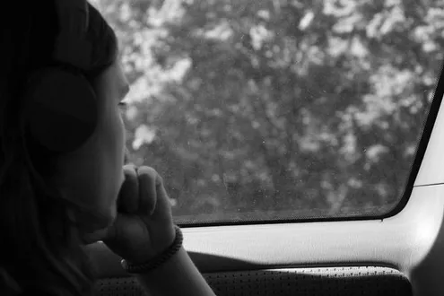 rson sat in a car stares out of the window contemplating why they are struggling with addiction