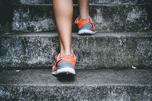 Runners trainers can be seen climbing concrete steps symbolising the 12 step programme for addiction