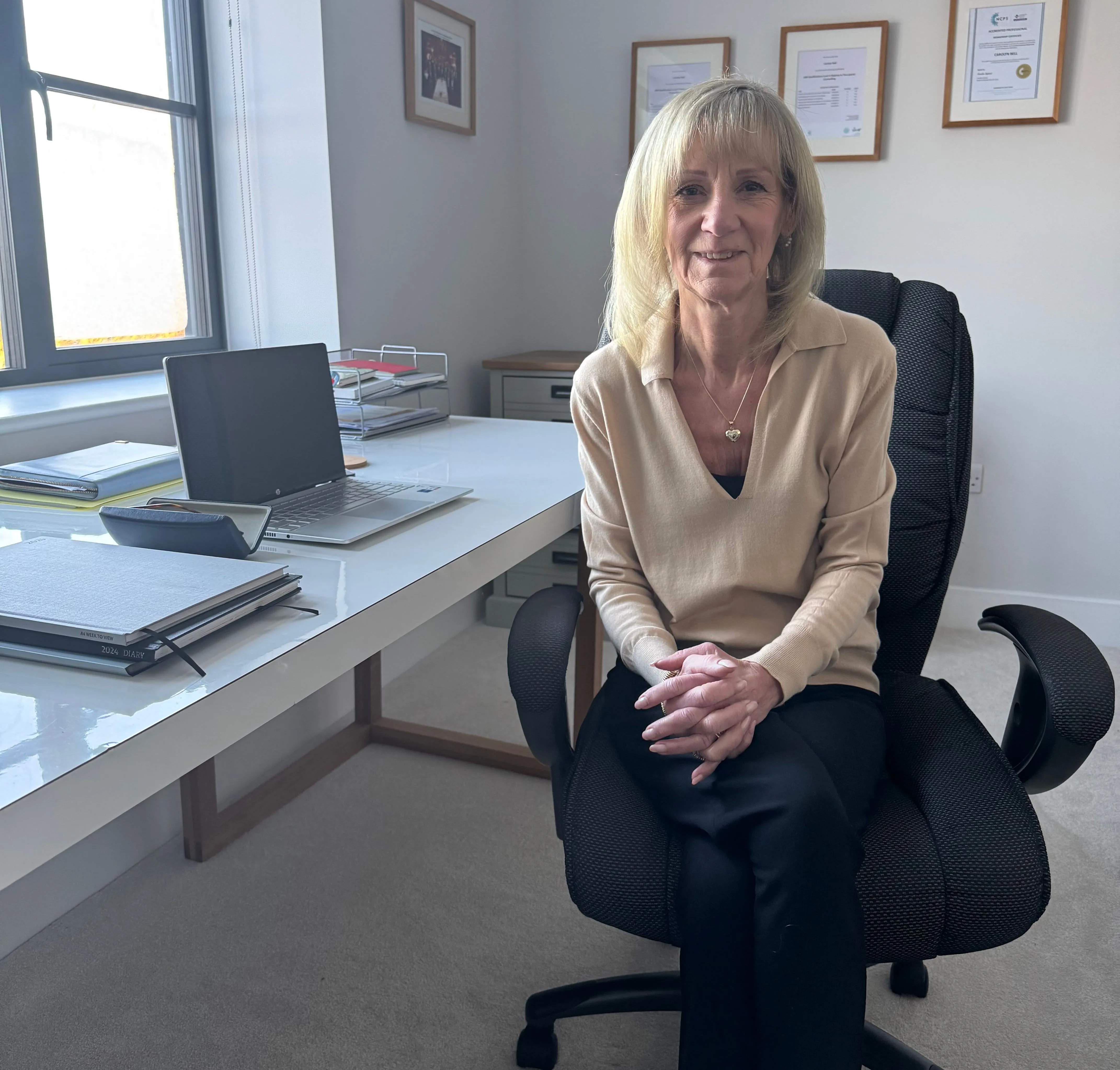 Picture of Carolyn Bell female EMDR Practitioner sat at her desk