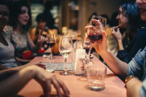 People socialising and drinking wine, highlighting the issues of socially acceptable addiction